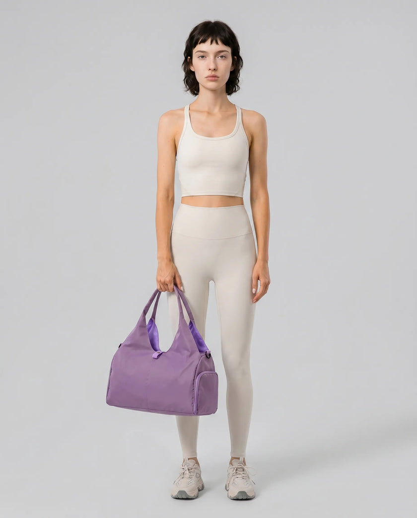 Model carrying CarryForm Studio Bag in red violet styled for gym and everyday use