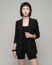 Woman wearing black CityLine tailored blazer with structured lapel collar and pocket details styled for elevated streetwear looks