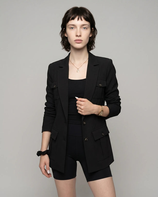 Woman wearing black CityLine tailored blazer with structured lapel collar and pocket details styled for elevated streetwear looks