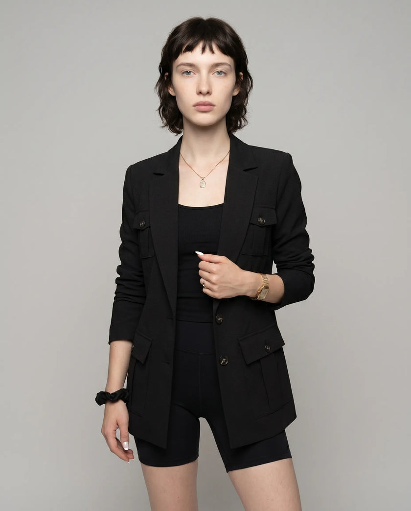 Woman wearing black CityLine tailored blazer with structured lapel collar and pocket details styled for elevated streetwear looks
