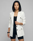 Woman wearing white CityLine tailored blazer with structured lapel collar and pocket details styled for elevated streetwear looks