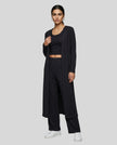Woman wearing the CloudEase Lounge Set in black front view with cropped tank wide-leg pants and long sleeve cover-up