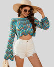 Side angle mid-body view of the Athlesi ColorRush Wave Knit Top highlighting cropped silhouette and knit drape in light blue