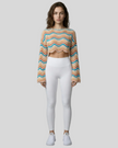 Front full-body view of the Athlesi ColorRush Wave Knit Top in tan layered over an Athlesi sports bra and leggings