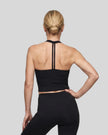 Back view of a model wearing the Contour Halter Yoga Tank Top in Black