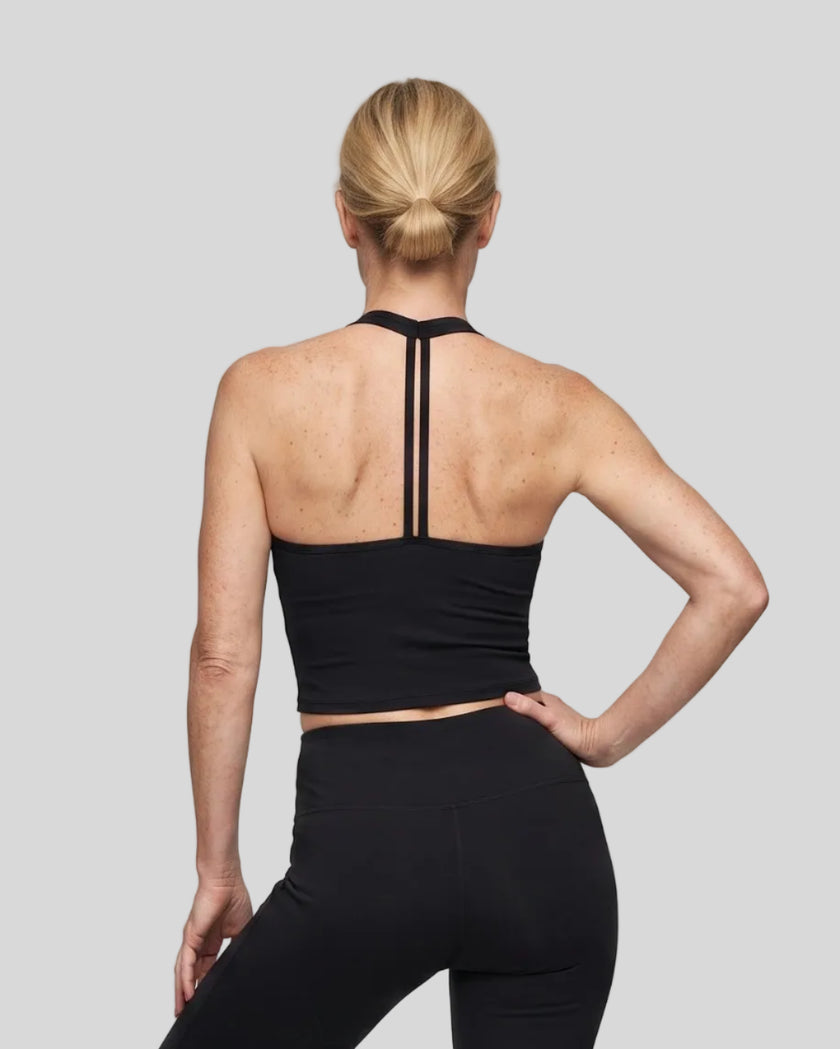 Back view of a model wearing the Contour Halter Yoga Tank Top in Black