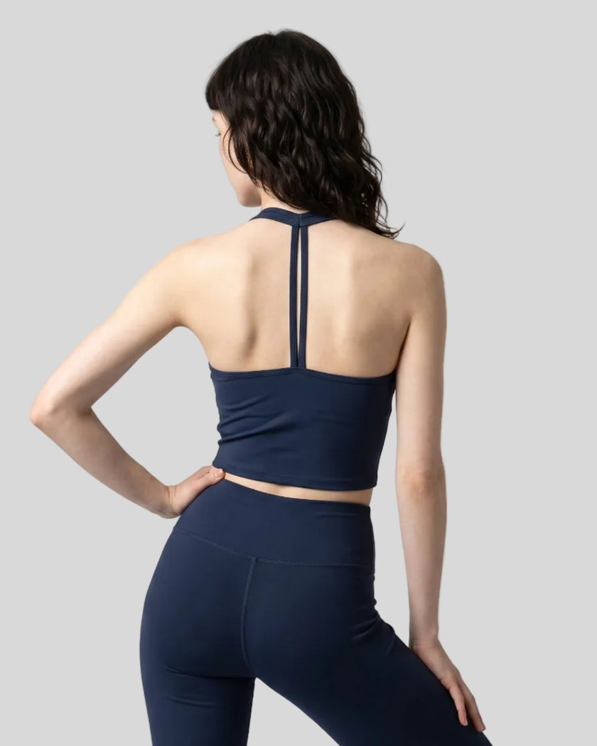 Back view of a model wearing the Contour Halter Yoga Tank Top in Navy Blue
