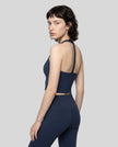 Side view of a model wearing the Contour Halter Yoga Tank Top in Navy Blue