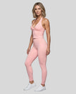 Full body front angle view of woman wearing Contour Ruched Yoga Top with matching activewear in pink