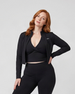 Mid body front view of woman wearing Contour Yoga Jacket in black unzipped