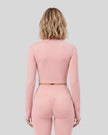 Mid body back view of woman wearing Contour Yoga Jacket in pink
