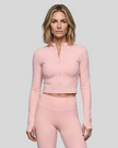 Mid body front view of woman wearing Contour Yoga Jacket in pink fully zipped