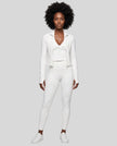 Full body front view of woman wearing unzipped Contour Yoga Jacket with matching white activewear