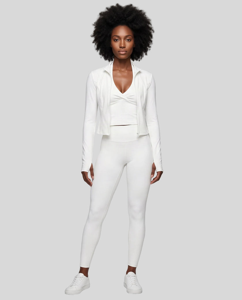 Full body front view of woman wearing unzipped Contour Yoga Jacket with matching white activewear