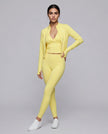 Full body front view of woman wearing unzipped Contour Yoga Jacket with matching yellow activewear