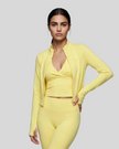 Mid body front view of woman wearing Contour Yoga Jacket in yellow unzipped