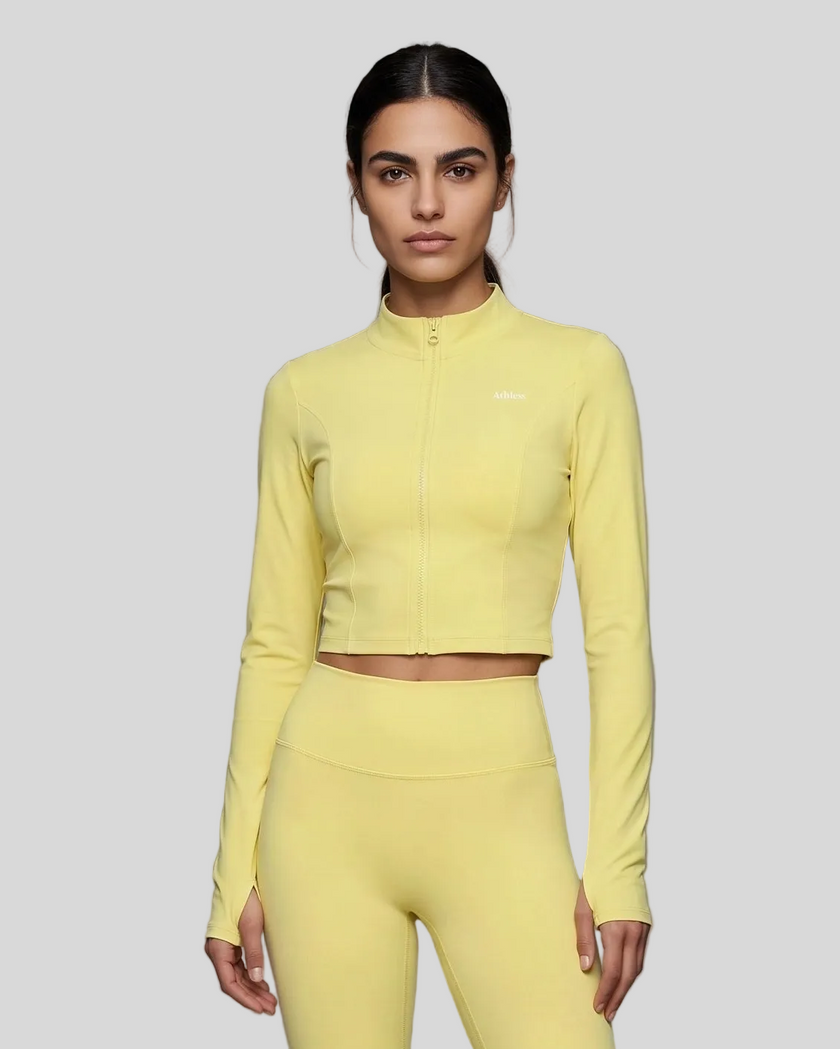 Mid body front view of woman wearing Contour Yoga Jacket in yellow fully zipped