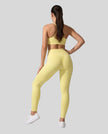 Full body back view of woman wearing Contour Yoga Leggings with matching Contour activewear in yellow