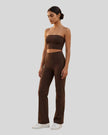 Front angle view of a model wearing the Contour Yoga Pants in Brown