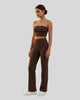 Front angle view of a model wearing the Contour Yoga Pants in Brown