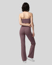 Model wearing the size small Contour Yoga Pants in Plum Purple, back full body view