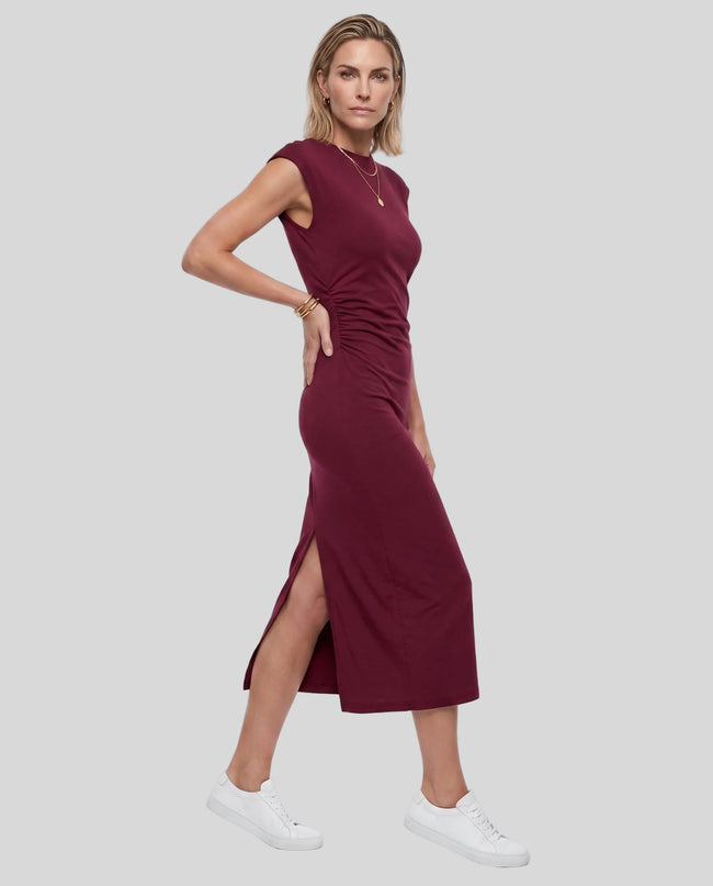 Woman wearing the ContourEase Ruched Maxi Dress in Wine Red, angled front view highlighting ruched waist detail
