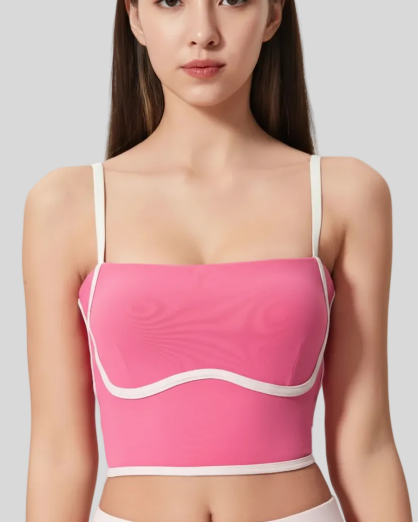 Woman wearing a pink top with white accents on a gray background