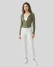 Model wearing an army green ContourZip Ribbed Jacket and white leggings in a clean studio setting