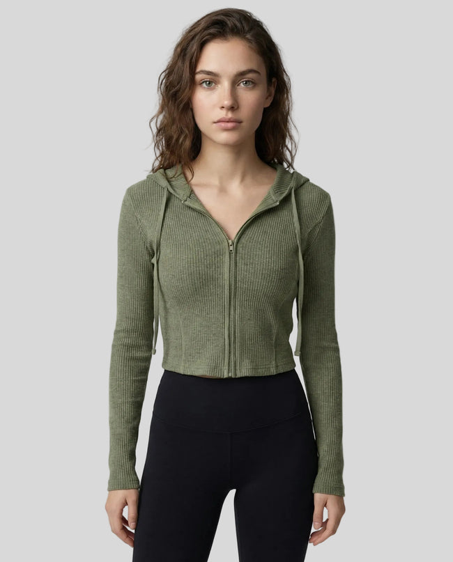 Mid shot of model wearing a army green ContourZip Ribbed Jacket and black leggings in a clean studio setting