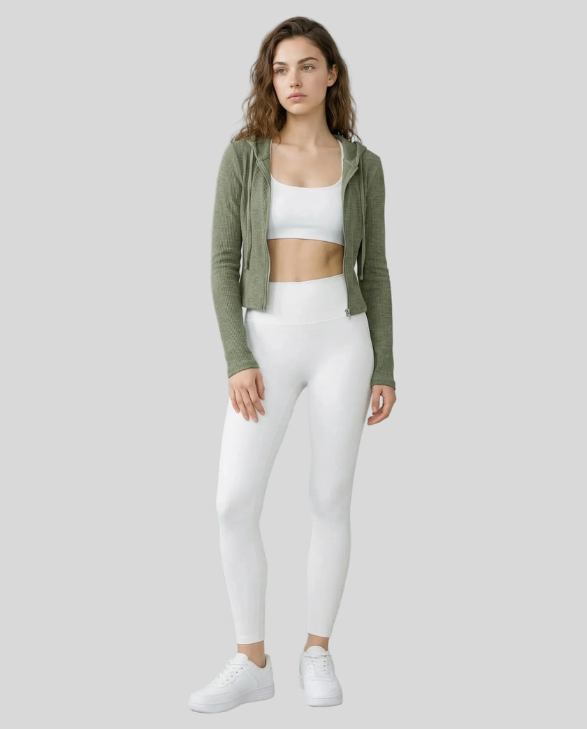 Model wearing an open front army green ContourZip Ribbed Jacket and white leggings in a clean studio setting
