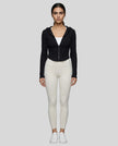 Model wearing a black ContourZip Ribbed Jacket and white leggings in a clean studio setting