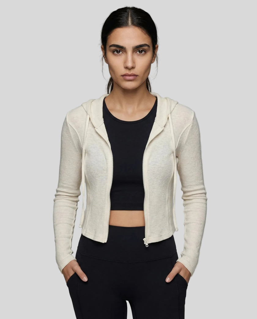 Mid shot of model wearing an open front khaki ContourZip Ribbed Jacket and black leggings in a clean studio setting