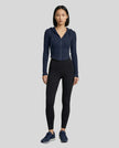 Model wearing a navy blue ContourZip Ribbed Jacket and black leggings in a clean studio setting