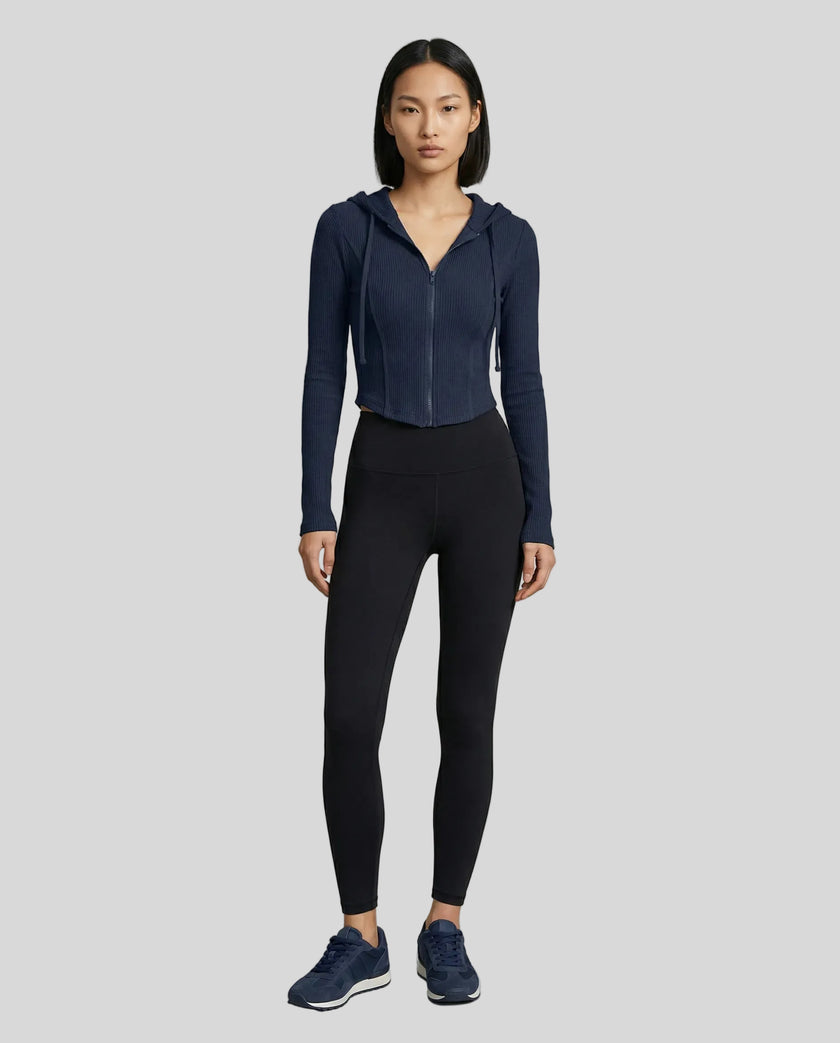Model wearing a navy blue ContourZip Ribbed Jacket and black leggings in a clean studio setting
