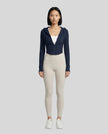 Model wearing a navy ContourZip Ribbed Jacket and white leggings in a clean studio setting