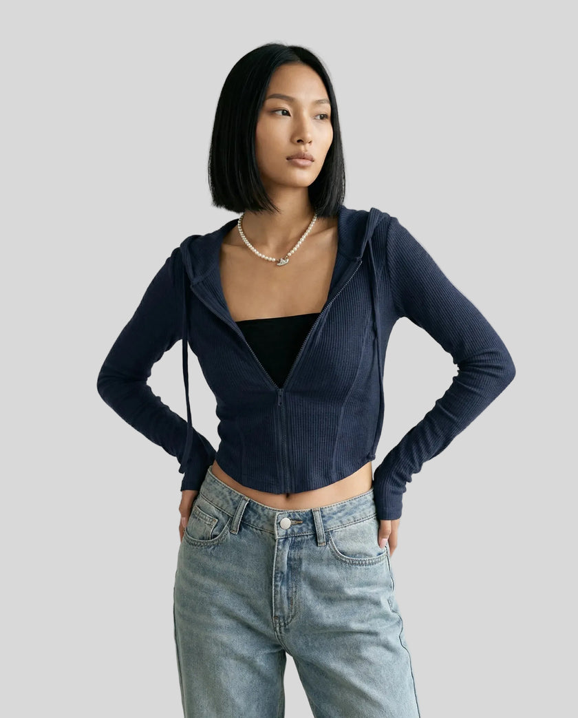 Mid shot of model wearing a navy ContourZip Ribbed Jacket with jeans in a clean studio setting