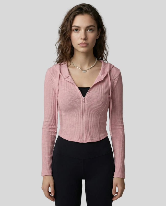 Mid shot of model wearing a pink ContourZip Ribbed Jacket and black leggings in a clean studio setting