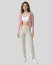 Model wearing an open front pink ContourZip Ribbed Jacket and white leggings in a clean studio setting