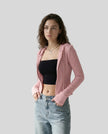 Mid shot of model wearing an open front pink ContourZip Ribbed Jacket with jeans in a clean studio setting