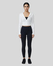 Model wearing a white ContourZip Ribbed Jacket and black leggings in a clean studio setting