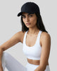 CoreForm Essential Cap in black worn by model in a clean studio setting with a white sports bra and leggings