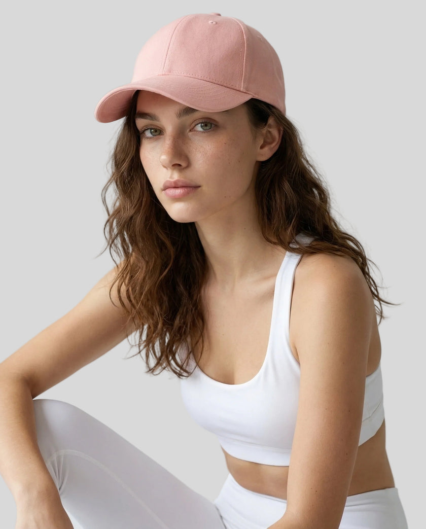 CoreForm Essential Cap in blush pink worn by model in a clean studio setting with a white sports bra and leggings