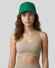 CoreForm Essential Cap in dark green worn by model in a clean studio setting with a beige sports bra and leggings