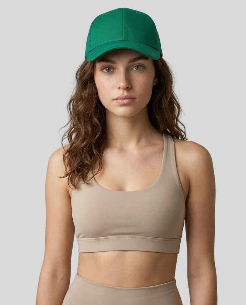 CoreForm Essential Cap in dark green worn by model in a clean studio setting with a beige sports bra and leggings