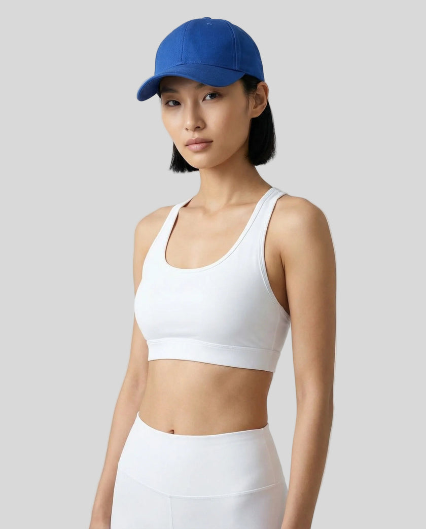 CoreForm Essential Cap in royal blue worn by model in a clean studio setting with a white sports bra and leggings