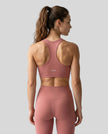 CoreForm Sports Bra in brick red, back view styled on model