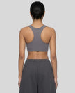 Back view of woman wearing Athlesi dark purple CoreForm sports bra
