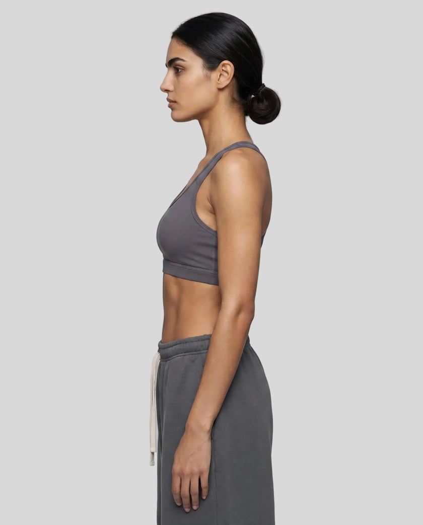 Left side view of woman wearing Athlesi dark purple CoreForm sports bra