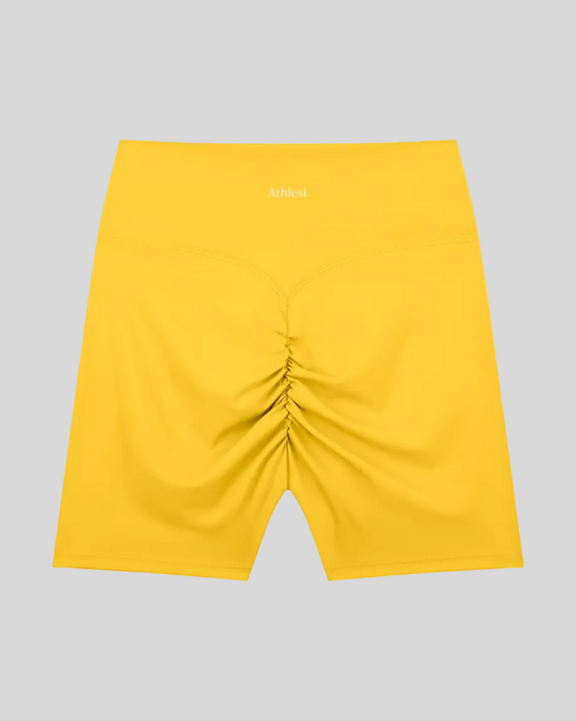 CoreLine Biker Shorts in yellow, flatlay back view