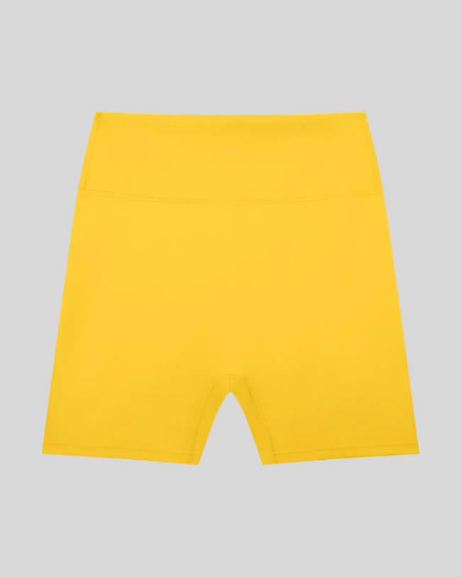 CoreLine Biker Shorts in yellow, flatlay front view